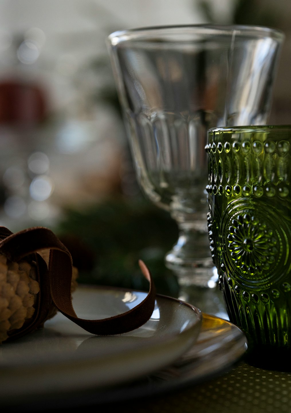 Elegante tavola apparecchiata con calice e decorazione di pigne.